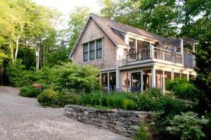 a house with a porch and a stone wall at Coveside Bed & Breakfast in Georgetown