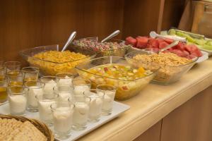 a buffet with bowls of food and glasses of milk at King David Flat Hotel - Argentina in Cordoba