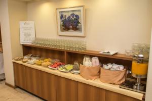 
a counter with a variety of food items on it at King David Flat Hotel - Argentina in Córdoba
