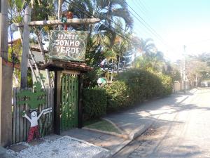 a sign on a gate in front of a street at Pousada Sonho Verde in Rio das Ostras