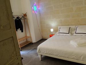 a bedroom with a white bed and a clothes rack at Le Luminarie B&B in Lecce