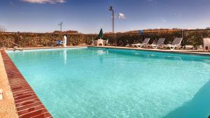 a large blue swimming pool with chairs and a fence at SureStay Hotel by Best Western Sonora in Sonora