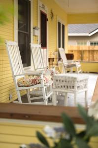 twee witte stoelen en een tafel op een veranda bij Poppy Sister Inn in Lodi