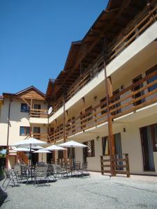 a patio with chairs and umbrellas in front of a building at Hostel Sea Star in Vama Veche