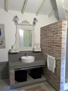 baño con lavabo y pared de ladrillo en B&B Mediterrando-soggiorni settimanali en San Litardo