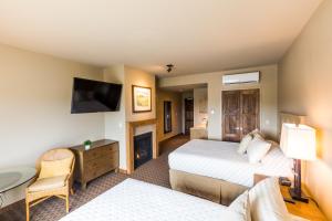 a hotel room with two beds and a television at The Lodge at Columbia Point in Richland