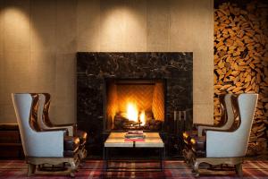 two chairs and a table in front of a fireplace at Andaz Napa - a concept by Hyatt in Napa