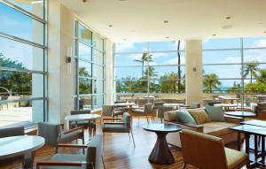 檀香山的住宿－威基基海灘凱悅水療度假酒店，餐厅设有桌椅和大窗户。