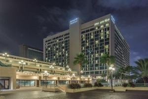 a large building with palm trees in front of it at Hyatt Regency Jacksonville Riverfront in Jacksonville