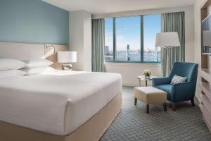 a hotel room with a large bed and a blue chair at Hyatt Regency Jacksonville Riverfront in Jacksonville