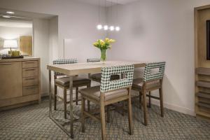 a dining room table with chairs and a vase of flowers at Hyatt Regency Jacksonville Riverfront in Jacksonville