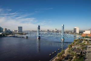 a blue bridge over a river with a city at Hyatt Regency Jacksonville Riverfront in Jacksonville