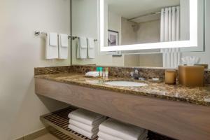 a bathroom with a sink and a mirror and towels at Hyatt Regency Jacksonville Riverfront in Jacksonville