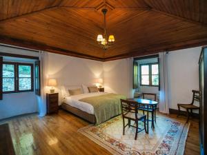 a bedroom with a bed and a table at Casas de Massinos in Barroselas +29 photos