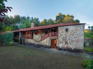 a stone house with a porch and a balcony at Casas de Massinos in Barroselas