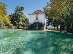 - un bâtiment avec une piscine d'eau en face dans l'établissement Casas de Massinos, à Barroselas