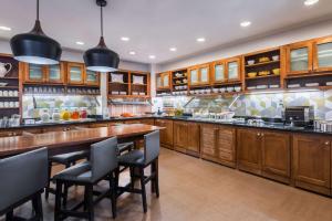 a large kitchen with wooden cabinets and a large wooden table at Hyatt Place Atlanta Duluth Johns Creek in Johns Creek