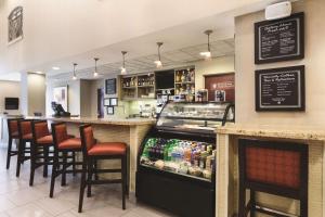 a restaurant with a bar with stools and a counter at Hyatt Place College Station in College Station