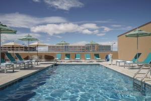 a pool on the roof of a hotel with chairs and umbrellas at Hyatt Regency Aurora-Denver Conference Center in Aurora
