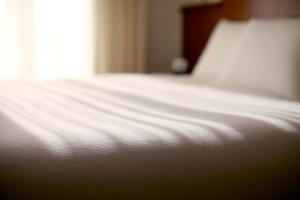 a close up of a white bed in a room at Hyatt Place Sarasota/Lakewood Ranch in Sarasota +31 photos