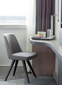 a white chair sitting in front of a window at Hyatt Place London Heathrow Airport in Hillingdon