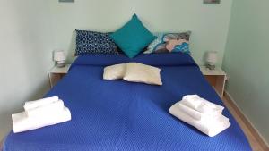 un letto blu con due asciugamani bianchi sopra di A Casa di Arturo a Napoli