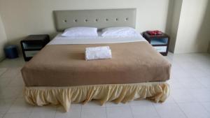 ein Schlafzimmer mit einem großen Bett mit einer braunen Decke in der Unterkunft Lumut Valley Resort Condominium in Lumut