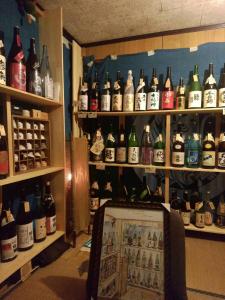 a room filled with lots of bottles of alcohol at Experiencing Traditional Life Style Inn Kajiya Iya Romantei in Miyoshi