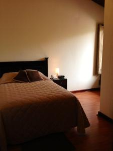 a bedroom with a bed and a lamp on a night stand at Comfort Hostel in Guatemala