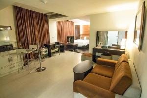 a living room with a couch and a room with a bed at Katherine Plaza Hotel in Kaohsiung