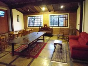 sala de estar con mesa de madera y sillas en Pousada Danza - Centro, en Poços de Caldas