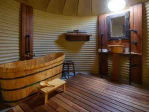 uma casa de banho com uma banheira de madeira e um lavatório em Truffle Lodge Dinner Bed Breakfast Glamping em Gretna