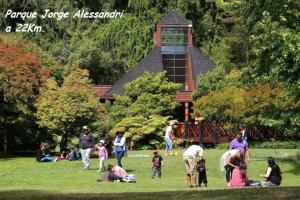 a group of people sitting in the grass in a park at Casa San Valentin in Concepción