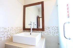a bathroom with a white sink and a mirror at Rama House in Ubud