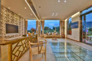 uma sala de estar com uma mesa de vidro e uma televisão em Yunshuo Dali Light luxury Guesthouse em Dali