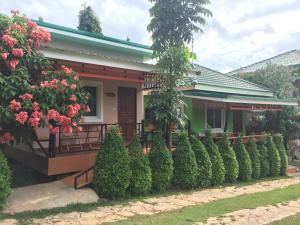 a house with a row of hedges in front of it at ฺBaan Ing Khao Resort in Muaklek