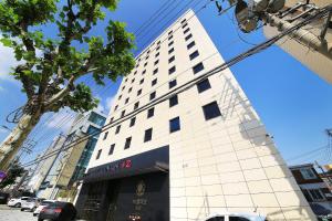 a tall white building on a city street at Hotel Cullinan 2 Geondae in Seoul