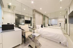 a bedroom with a bed and a desk with a laptop at Hotel Cullinan 2 Geondae in Seoul