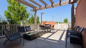 a patio with chairs and a table and a wooden pergola at Best Western Plus Patterson Park Inn in Arkansas City
