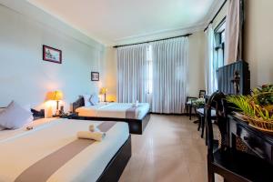 Angkor Panoramic Boutique Hotel في سيام ريب: غرفة فندقية بسريرين ونافذة كبيرة