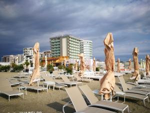 a group of chairs and umbrellas on a beach at Luxury Studio 42 De Silva in Mamaia