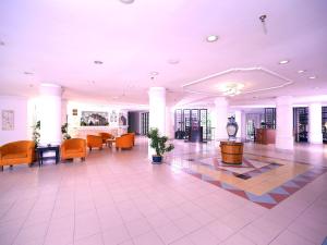 a lobby with chairs and a table in a building at Bella Vista Express Hotel in Pantai Cenang