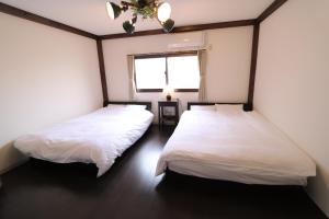 En eller flere senge i et værelse på GUEST HOUSE E-NINE