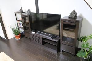einen großen Flachbild-TV im Wohnzimmer in der Unterkunft GUEST HOUSE E-NINE in Kyoto