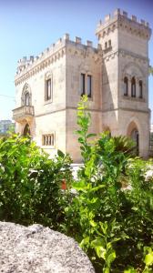 ein Steingebäude mit einem Baum davor in der Unterkunft Rocca Giulia in Ostuni