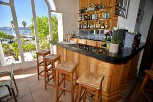 a bar with stools and a counter with a view at Auberge De La Calanque in Le Lavandou