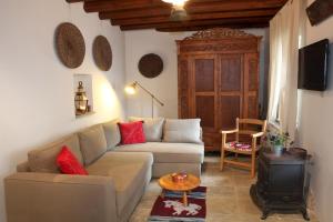 ein Wohnzimmer mit einem Sofa und einem Holzofen in der Unterkunft Kalopanayiotis Cottage in Kalopanagiotis