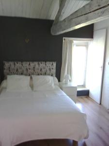 a bedroom with a white bed and a window at la Rosaliere in Chabournay