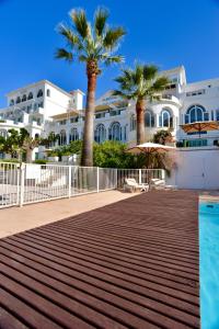 een resort met palmbomen en een zwembad bij Auberge De La Calanque in Le Lavandou