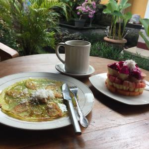 un tavolo con due piatti di cibo e una tazza di caffè di Wayan Guest House ad Ubud Altre 29 foto